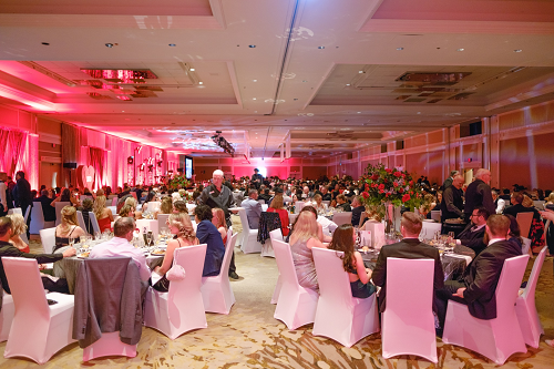 Ballroom full of people seated for dinner.